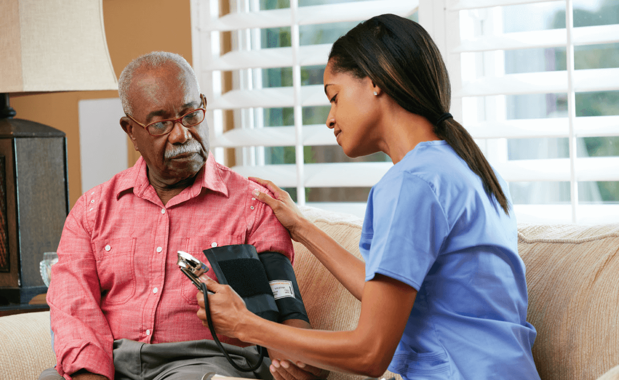 nurse checking blood pressure on an elderly man